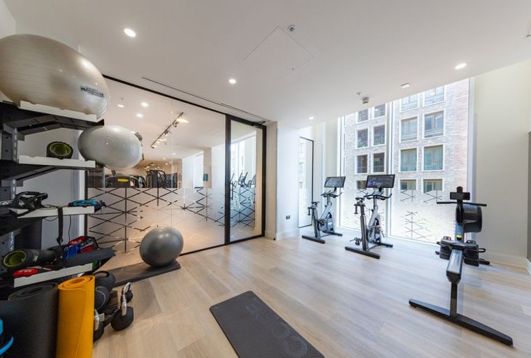 A gym with exercise bikes, a rowing machine, and exercise balls.
