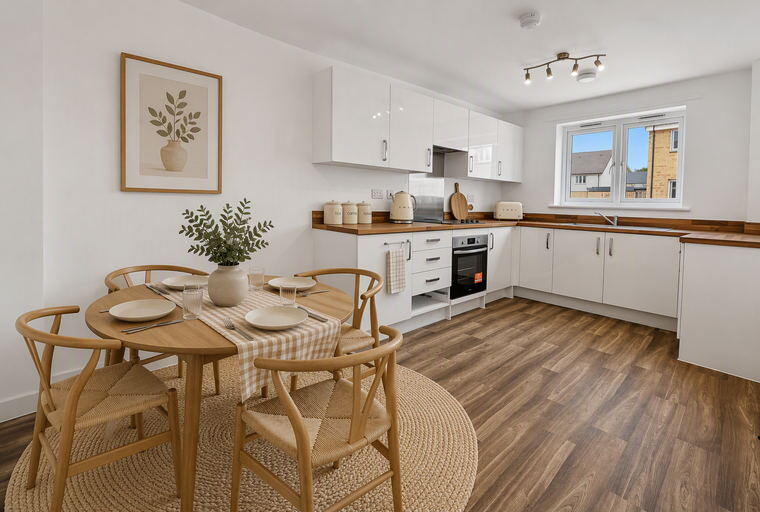 A kitchen and dining area with a round table, chairs, and modern white cabinets.