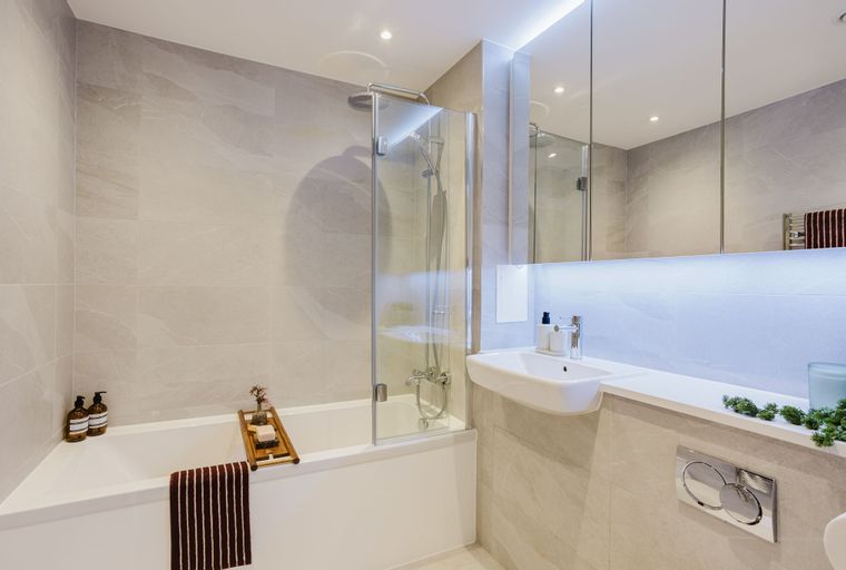 A bathroom with a bathtub, shower, sink, and mirror.