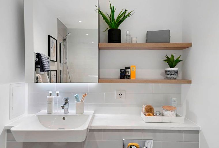 A bathroom vanity with a sink, mirror, and shelves.