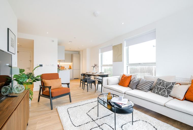 A living room and dining area with a sofa, chairs, and a dining table.