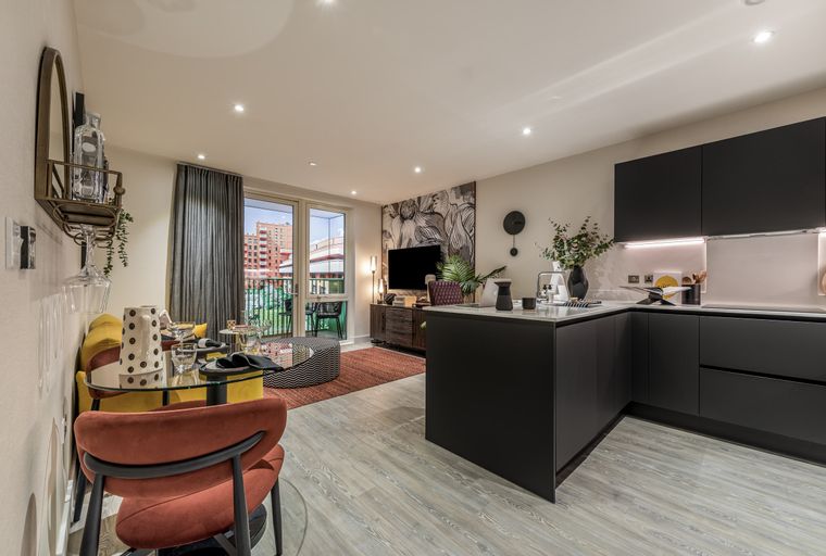 A modern apartment living room and kitchen area with a dining table and balcony.