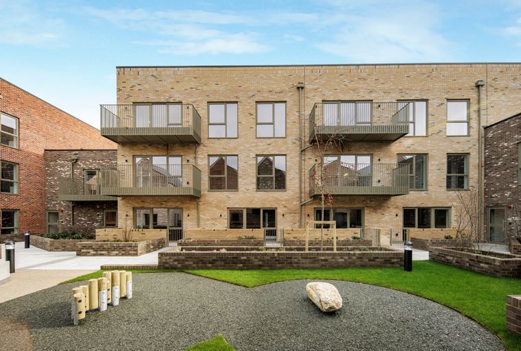 A modern apartment building with balconies and a courtyard.