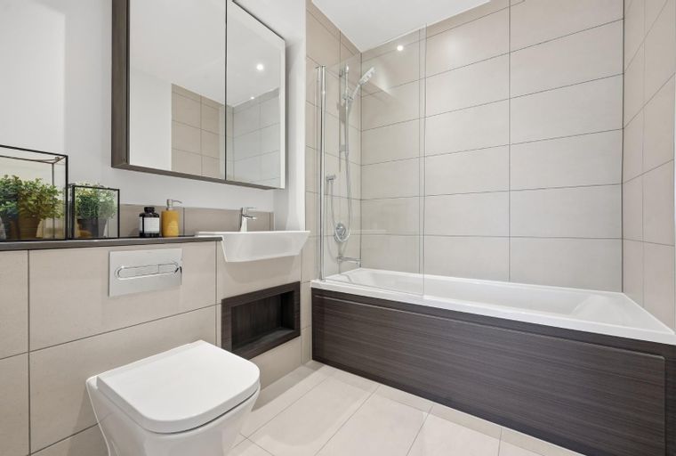 A modern bathroom with a toilet, sink, and bathtub.