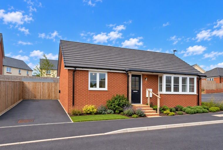 A brick bungalow with a front door, windows, and a driveway.