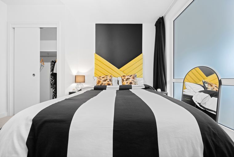 A bedroom with a bed, pillows, and a headboard.