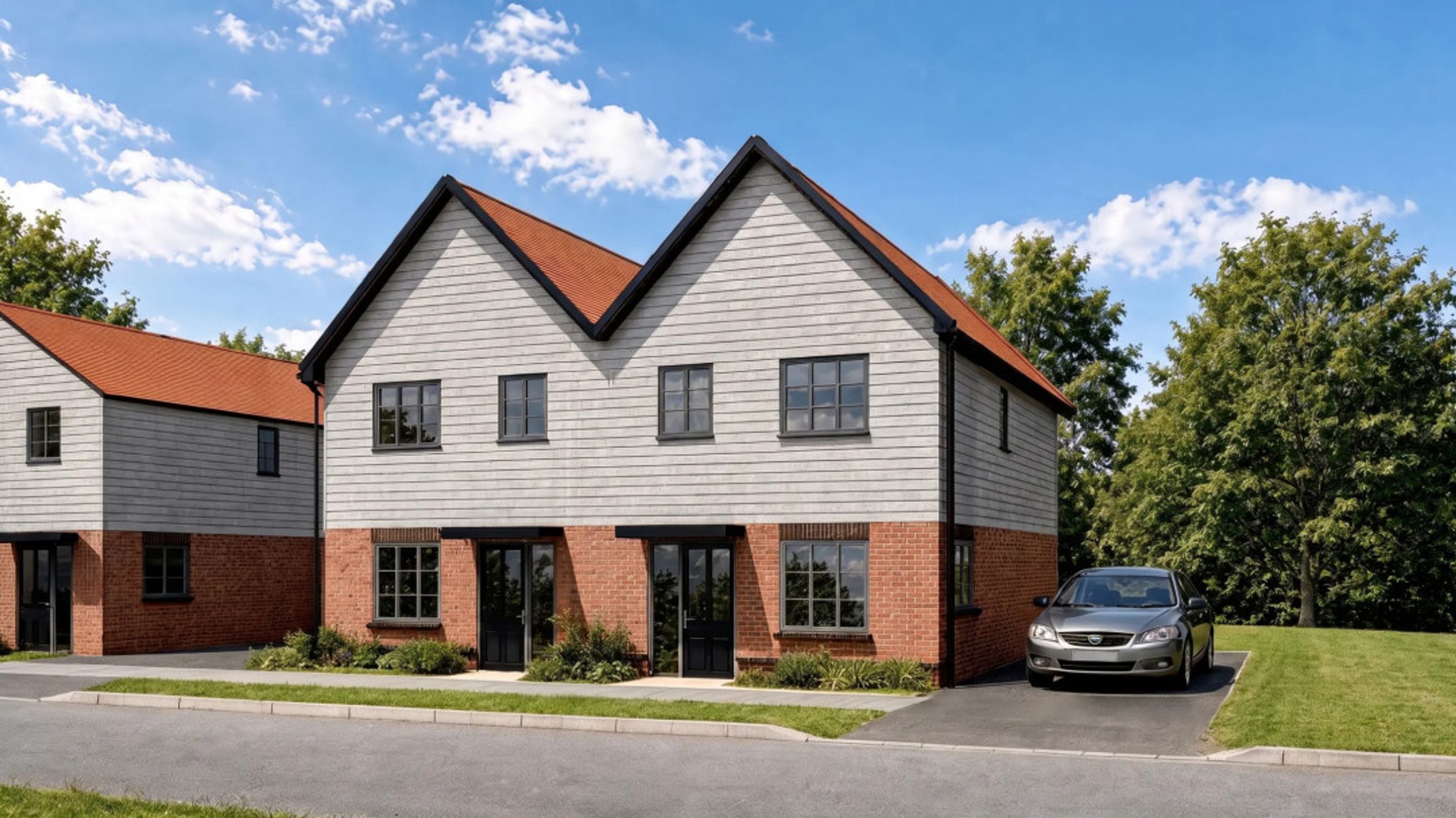 A pair of modern townhouses with brick lower levels and grey siding upper levels, featuring red tile roofs and dark windows, parked car on driveway.