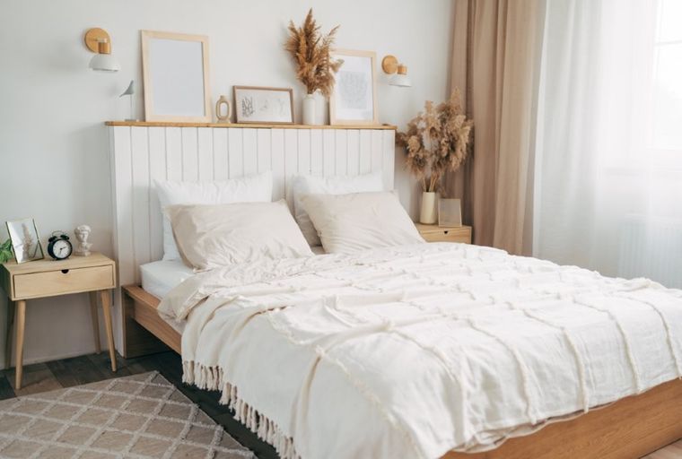 A bedroom with a bed, nightstand, and decorative items.