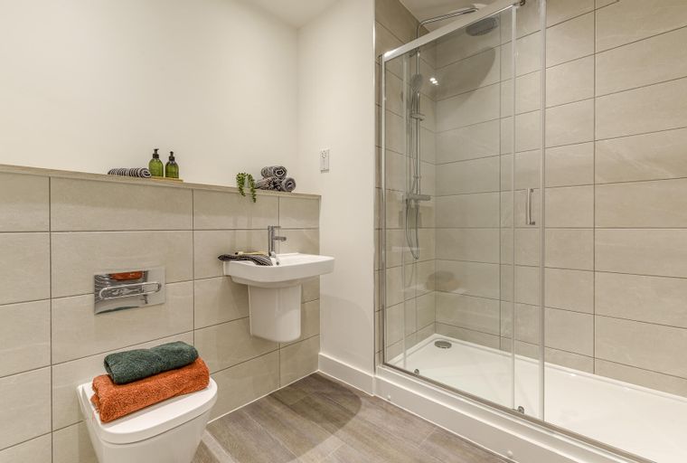 A bathroom with a shower, sink, and toilet.