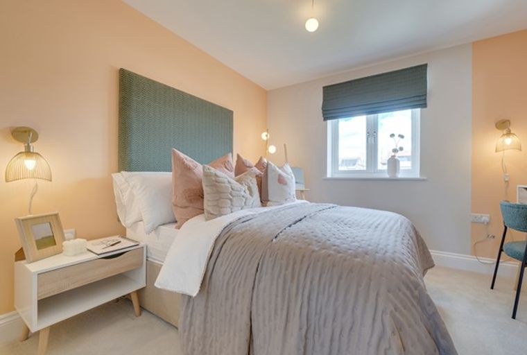A bedroom with a bed, headboard, bedside table, and a window.