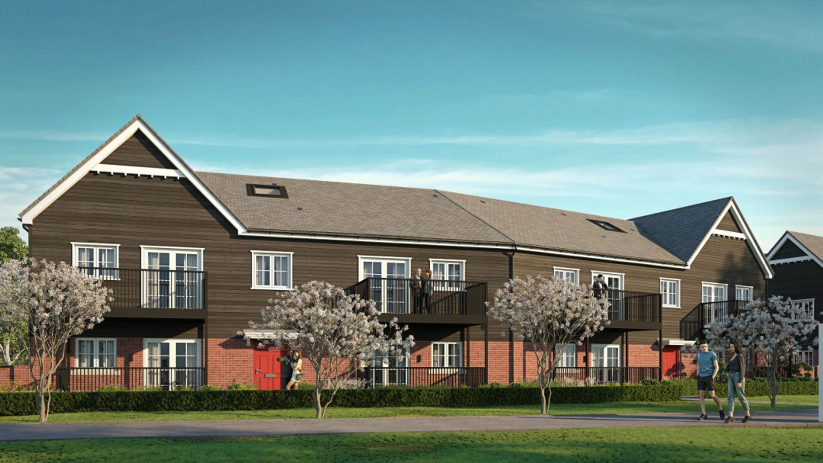 A row of modern townhouses with dark wood siding, red brick lower levels, and balconies.