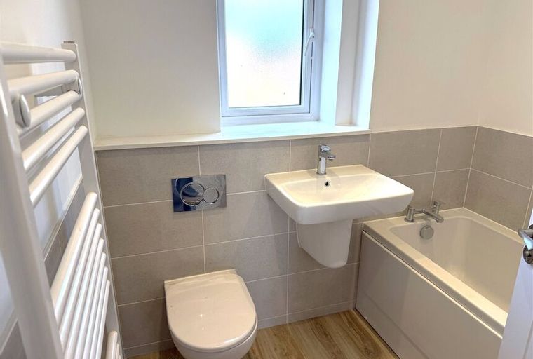 A bathroom with a toilet, sink, and bathtub.