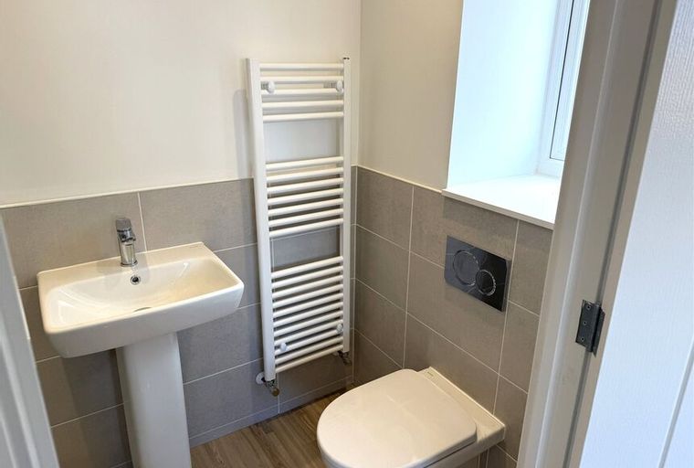 A bathroom with a sink, toilet, and towel radiator.