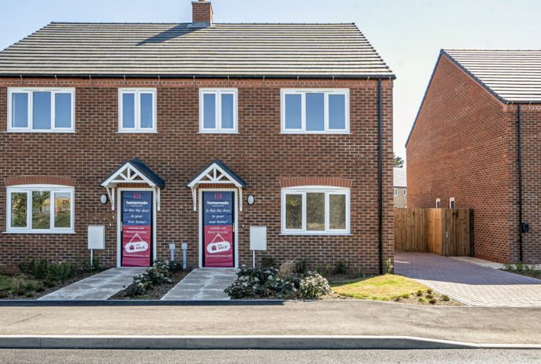 A row of new brick houses with white windows and front doors.