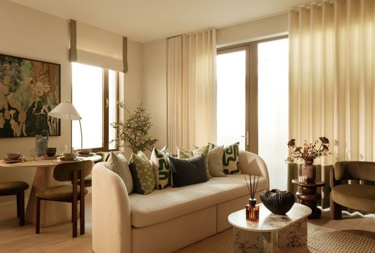 A living and dining area with a sofa, dining table, chairs, and a lamp.