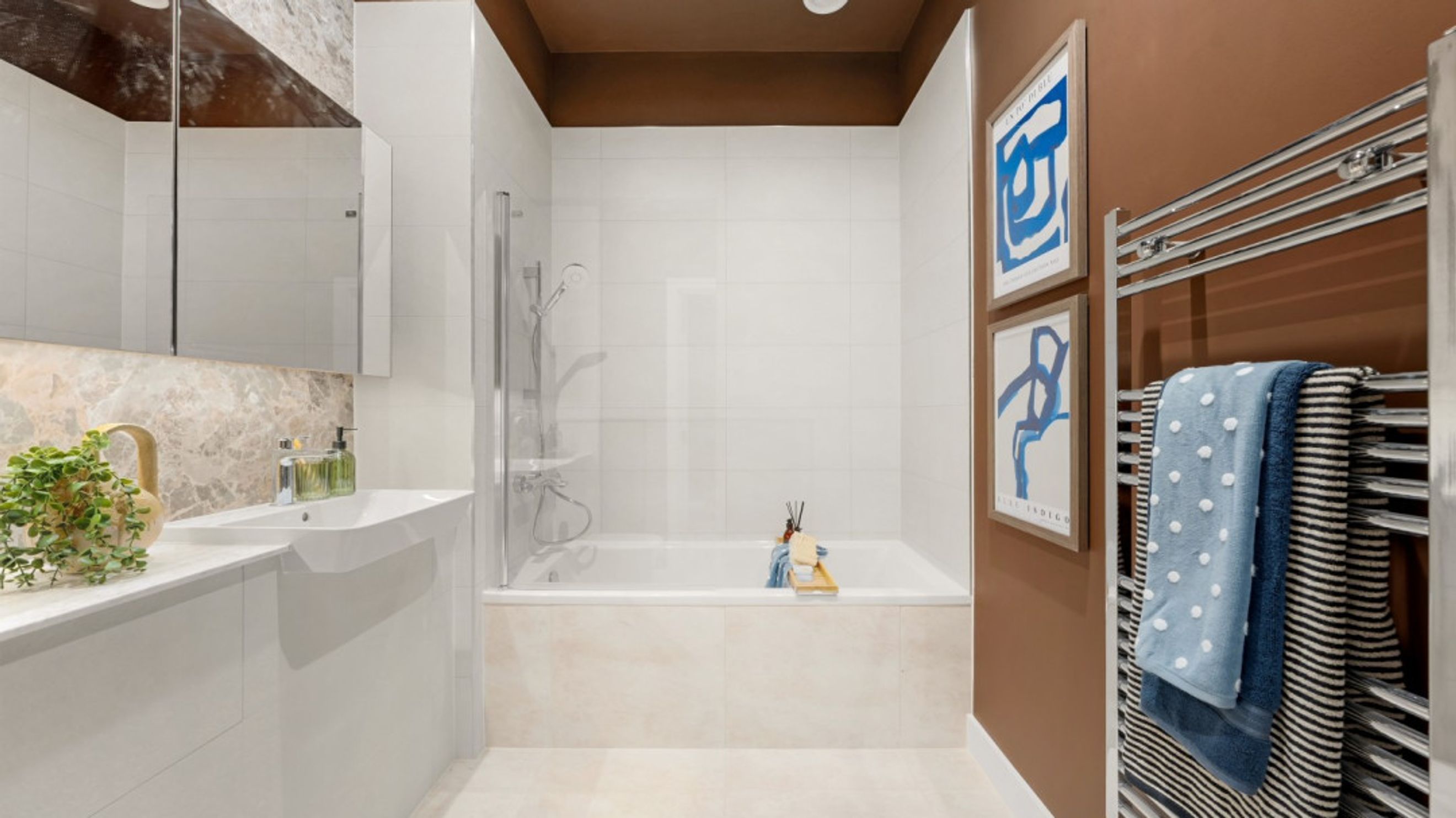 A bathroom with a bathtub, sink, and towels on a heated rack.