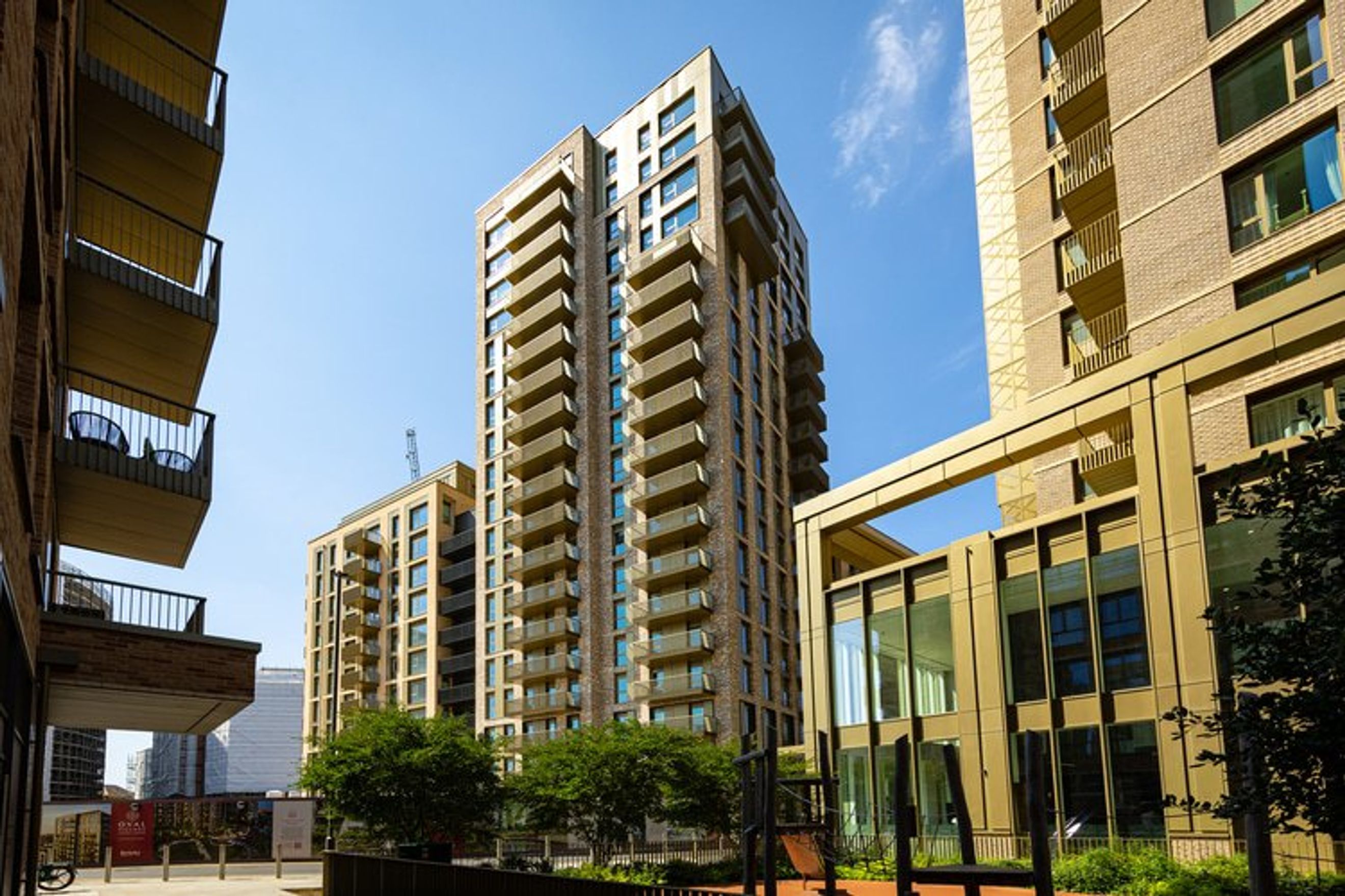 A modern apartment building with balconies and large windows.