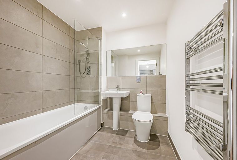 A bathroom with a bathtub, shower, sink, and toilet.