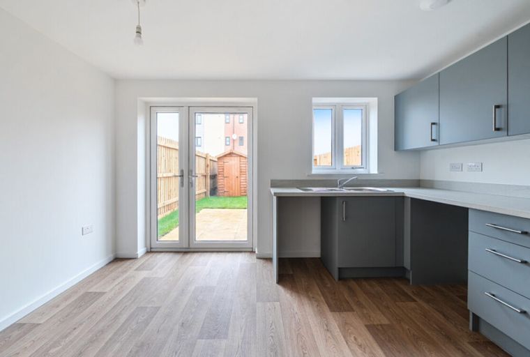 A modern kitchen with grey cabinets and a sink.