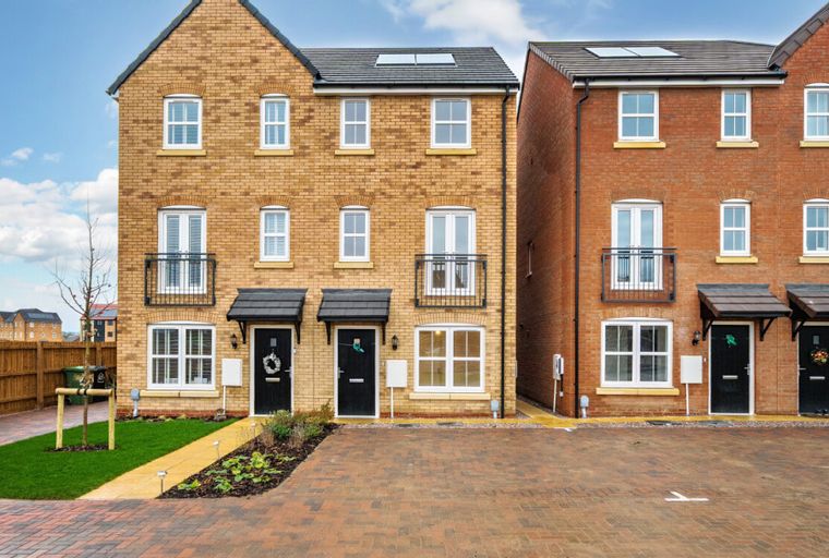 A row of new build houses with yellow and red brick facades.