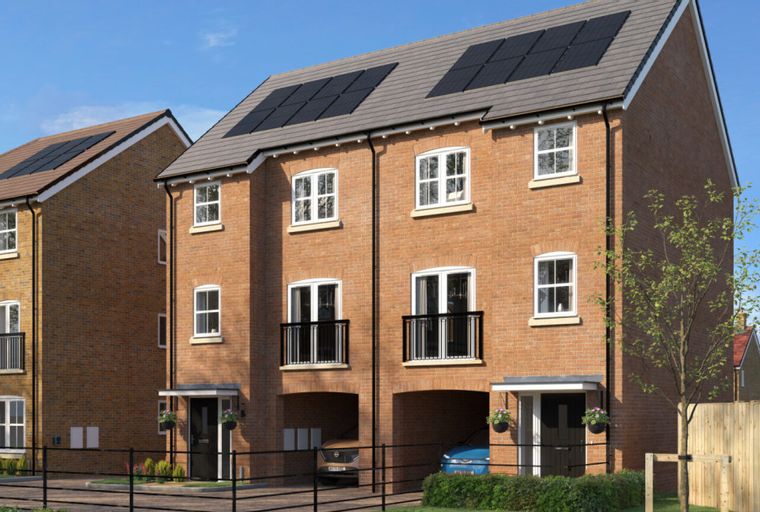 A row of modern brick townhouses with solar panels on the roofs.