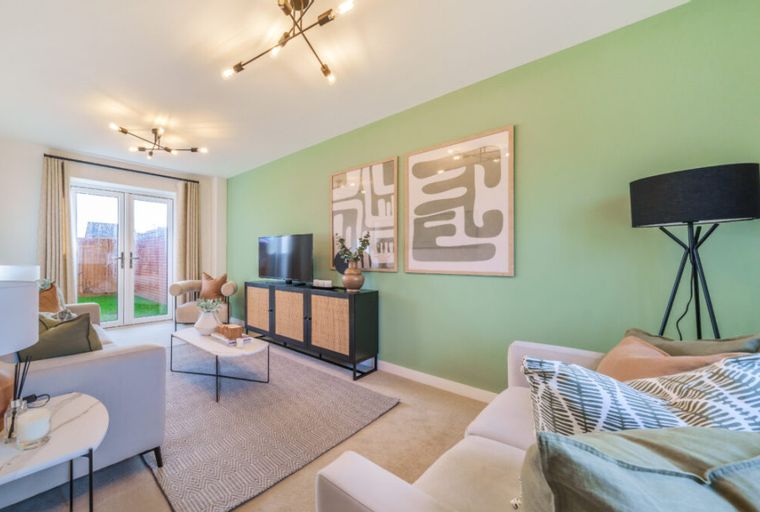 A living room with a TV, a cabinet, sofas, a coffee table, and a floor lamp.