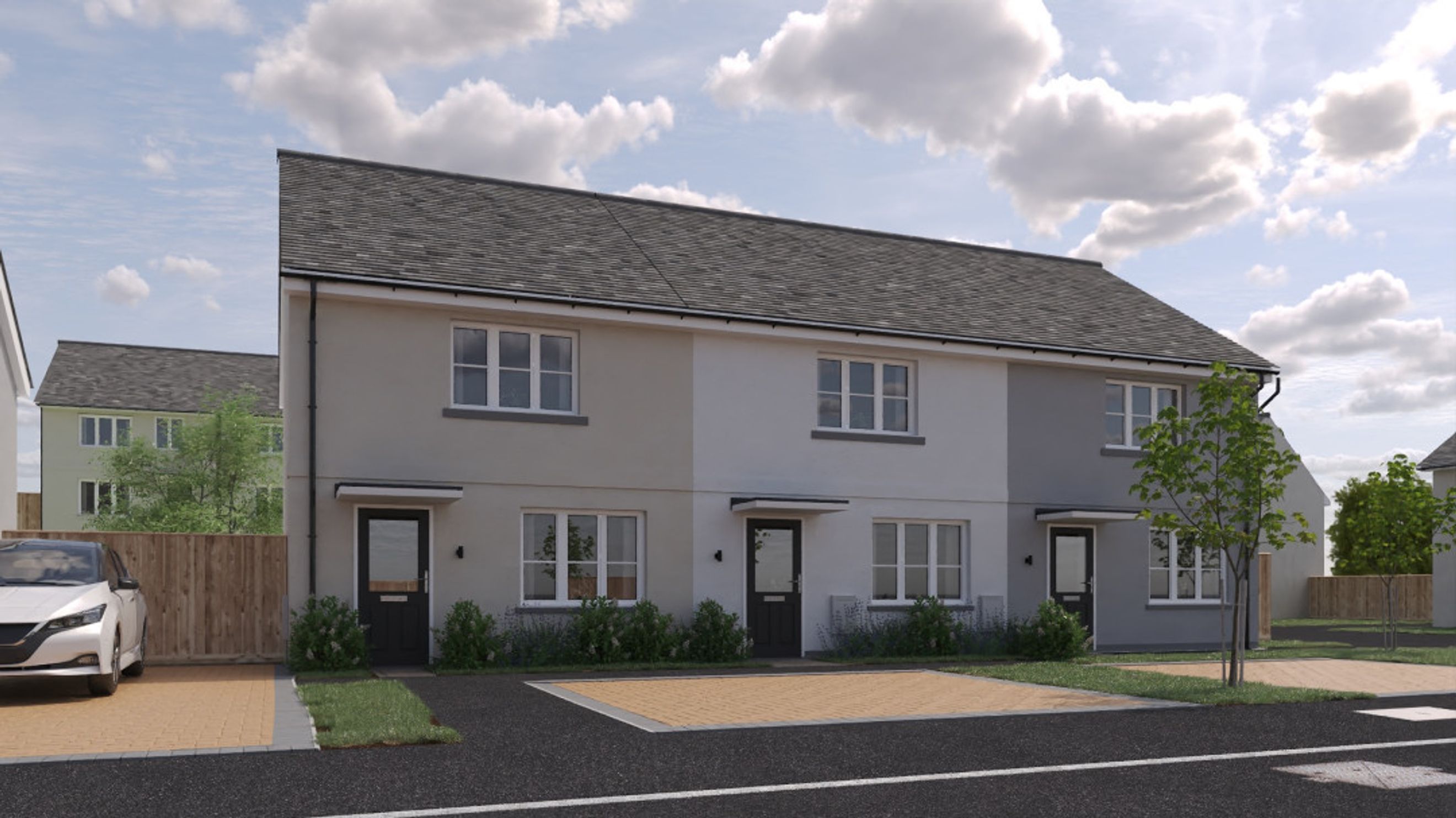 A row of modern townhouses with grey tiled roofs and two-tone exteriors.