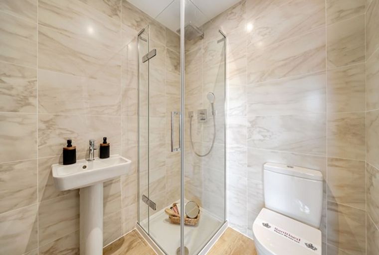 A bathroom with a sink, shower, and toilet.