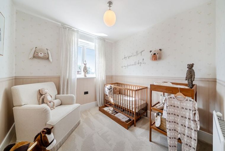 A nursery with a crib, armchair, and changing table.