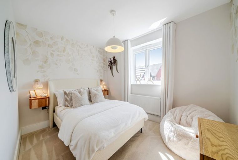 A bedroom with a bed, nightstands, a window, and a beanbag chair.