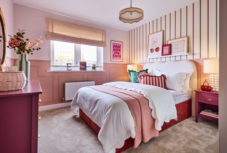 A bedroom with a bed, dresser, and nightstand.