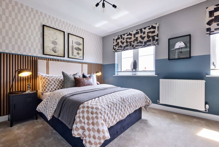A bedroom with a bed, bedside table, and artwork.