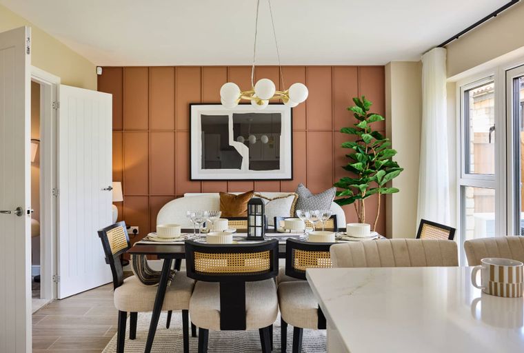 A dining room with a table, chairs, a sofa, and a chandelier.