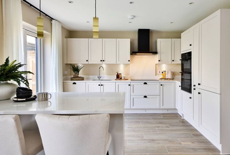 A modern kitchen with white cabinets, a black range hood, and a kitchen island.