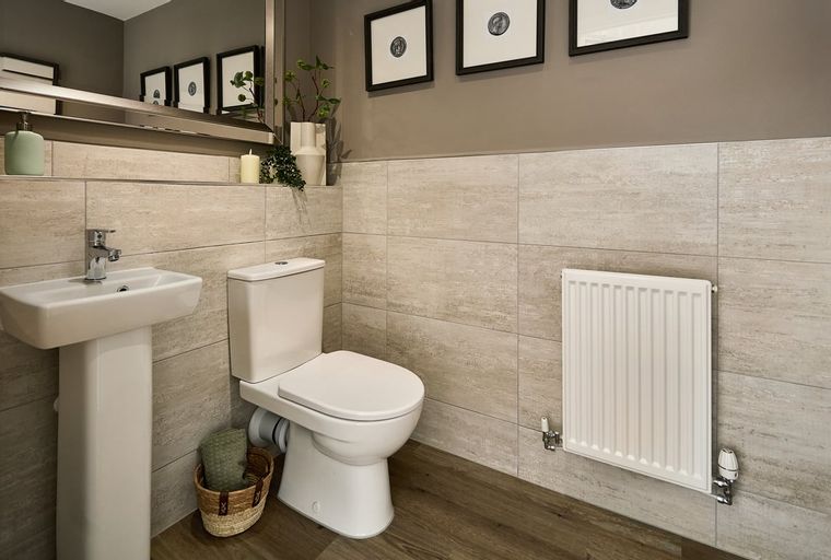 A bathroom with a sink, toilet, and radiator.