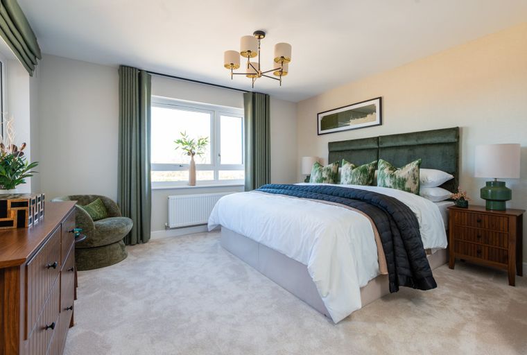 A bedroom with a bed, headboard, pillows, curtains, a window, a dresser, and a chandelier.