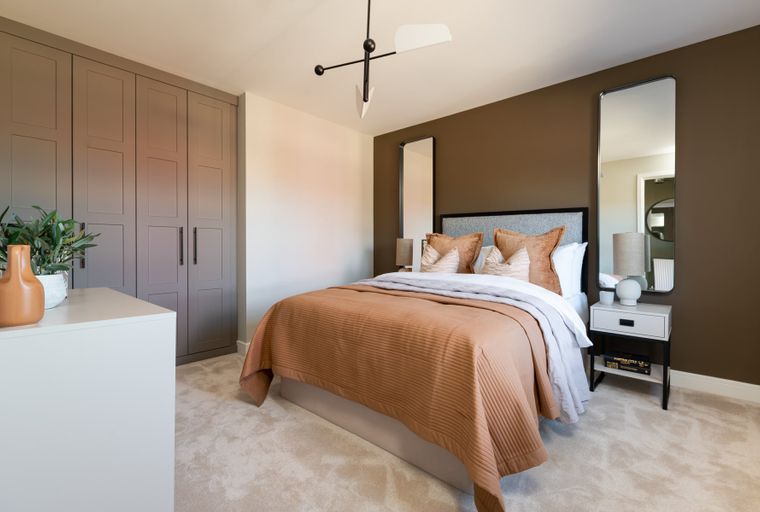 A bedroom with a bed, bedside table, and wardrobe.