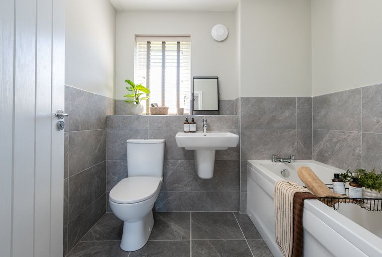 A bathroom with a toilet, sink, and bathtub.