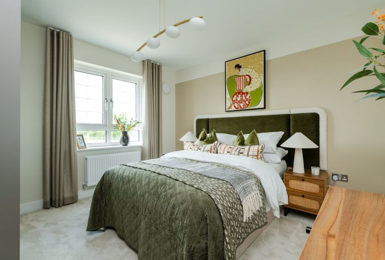 A bedroom with a bed, bedside table, and a window.