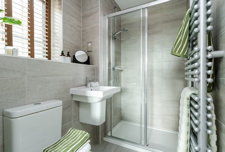 A bathroom with a toilet, sink, and shower.