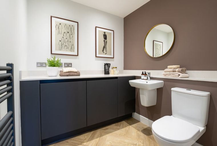 A bathroom with a sink, toilet, vanity, and a mirror.