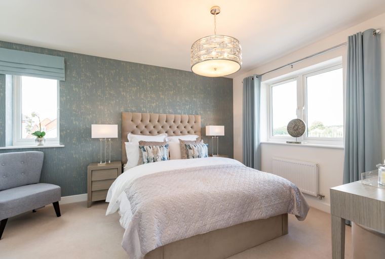 A bedroom with a bed, bedside tables, lamps, a chair, and a window.