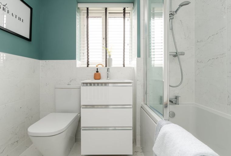 A bathroom with a toilet, sink, and bathtub.