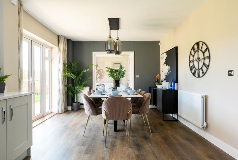 A dining room with a table, chairs, and pendant lights.