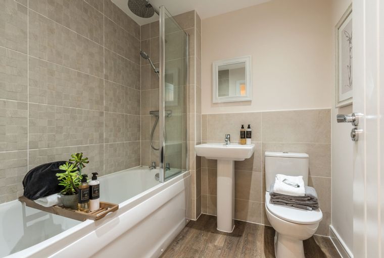 A bathroom with a bathtub, shower, sink, and toilet.