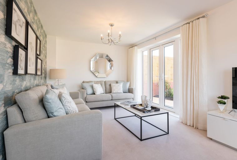 A living room with a sectional sofa, coffee table, and double doors.