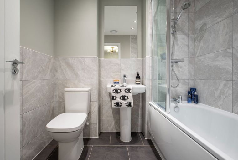 A bathroom with a toilet, sink, and bathtub with a shower.