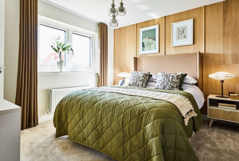 A bedroom with a bed, pillows, and a nightstand.