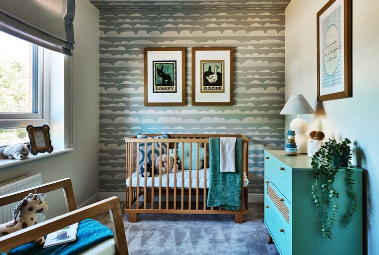 A nursery with a crib, dresser, and animal-themed artwork on a cloud-patterned wall.