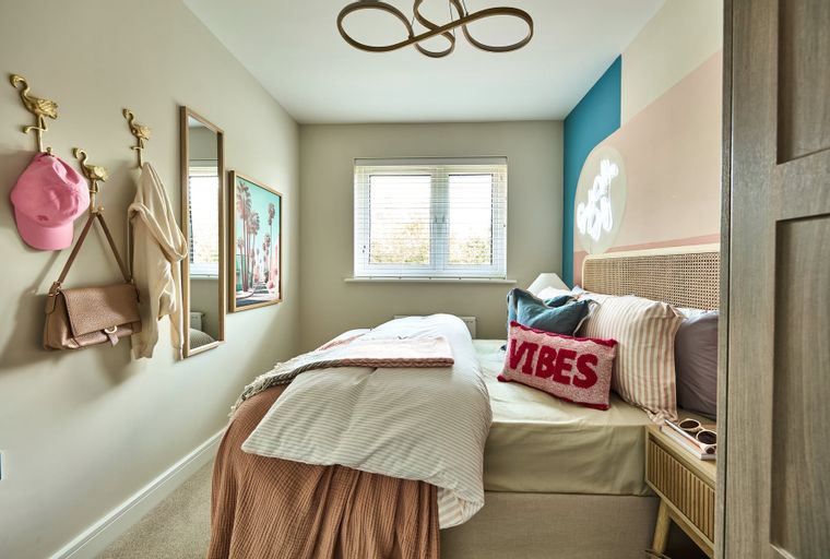 A bedroom with a bed, pillows, and a nightstand.
